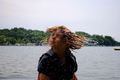 Beautiful woman standing in water against sky