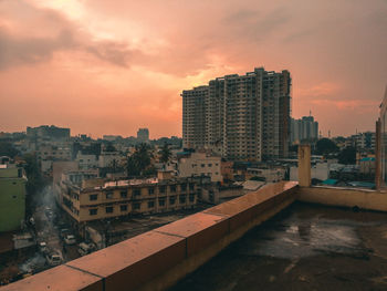 Buildings in city against sky during sunset