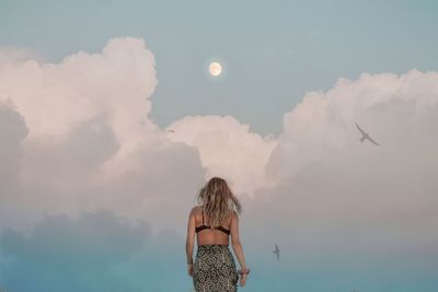 Rear view of woman standing against sky