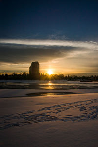 View of snow covered landscape during sunset