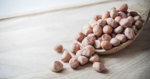 Close-up of hazelnuts with spoon on wooden table