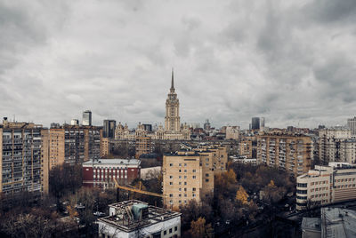 Buildings in city against cloudy sky