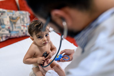 Doctor observing a one-year-old baby