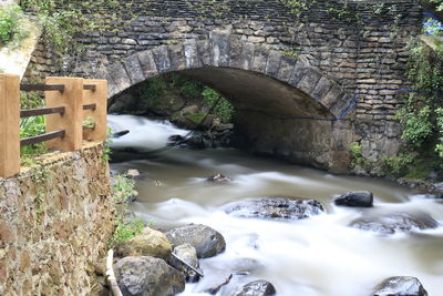 Bridge over river flowing through rocks