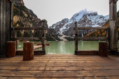 Wooden posts on snowcapped mountains against sky