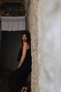 Young woman leaning on wall