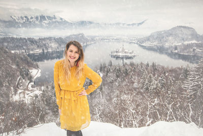 Portrait of woman standing on snow covered landscape during winter