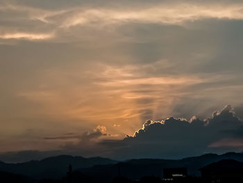 Scenic view of silhouette mountains against dramatic sky