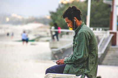 Side view of man sitting on beach