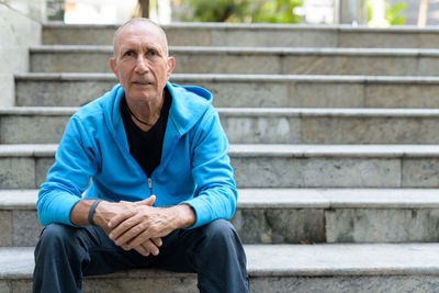 Portrait of man sitting on staircase