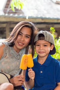 Portrait of mother and son having corn