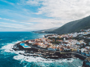 Aerial view of sea and buildings against sky