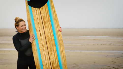 Woman standing at beach against sky