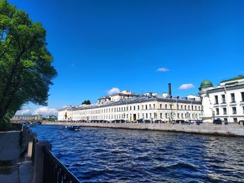 Buildings in city against clear blue sky