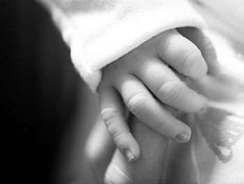 Close-up of parent holding baby hand