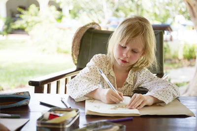 Girl writing in garden