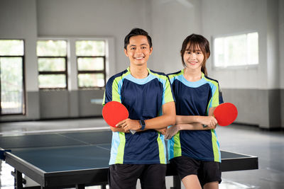 Portrait of young woman playing with ball on court