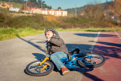 Portrait of boy riding bicycle on road in city