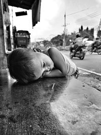 Cute boy lying on street in city