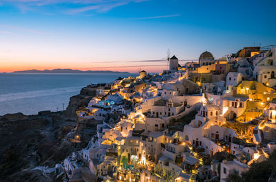 High angle view of townscape by sea against sky