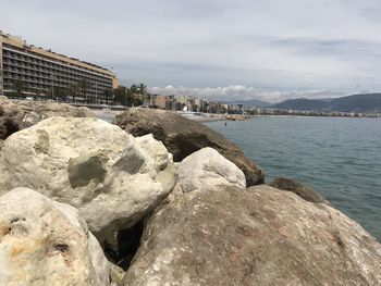 Rocks by sea against sky