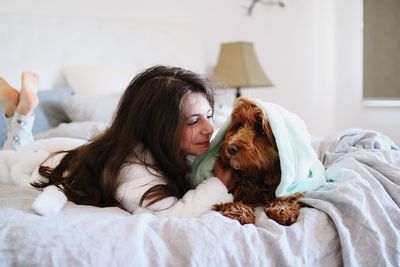 Woman lying down on bed at home