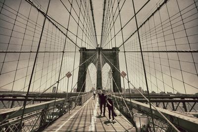 Rear view of people walking on railway bridge