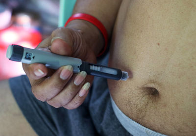 Close-up of man taking injection