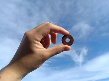 Low angle view of person hand against sky