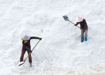 Man with umbrella standing in snow