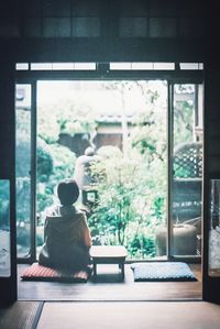 Rear view of people sitting in glass window