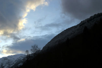 Low angle view of snowcapped mountains against sky