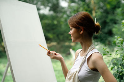 Side view of young woman using mobile phone