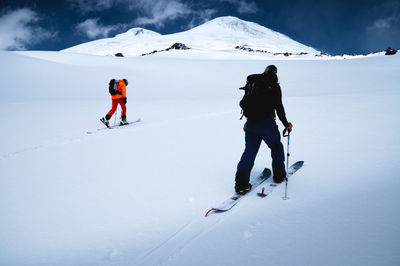 Two freeride skiers climb up the fresh snow in a ski tour. the summit of mount elbrus 