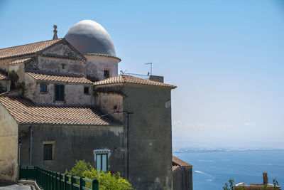 Building by sea against clear sky