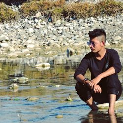 Full length of young man looking at lake