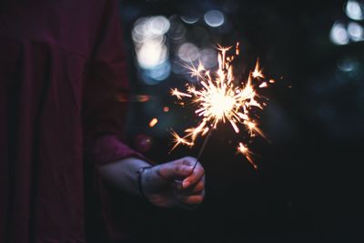 Close-up of hand holding sparkler at night