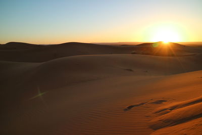 Scenic view of desert against sky during sunset