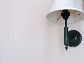 Low angle view of electric lamp on wall at home