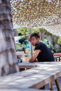 Full length of man sitting on table