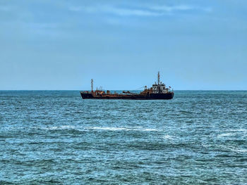 Boat sailing on sea against sky