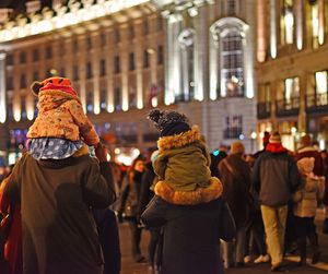 Rear view of people walking on city street