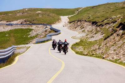 People riding motorcycle on mountain road