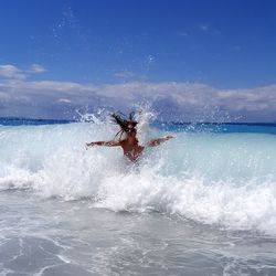 Man surfing on sea against sky