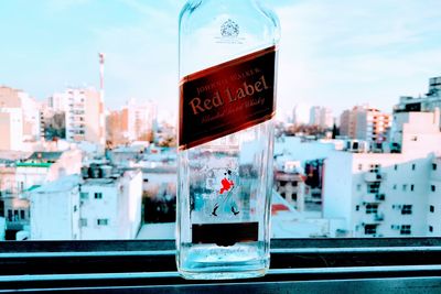 Close-up of information sign against buildings in city