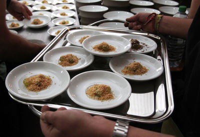Cropped image of hands holding tray with food