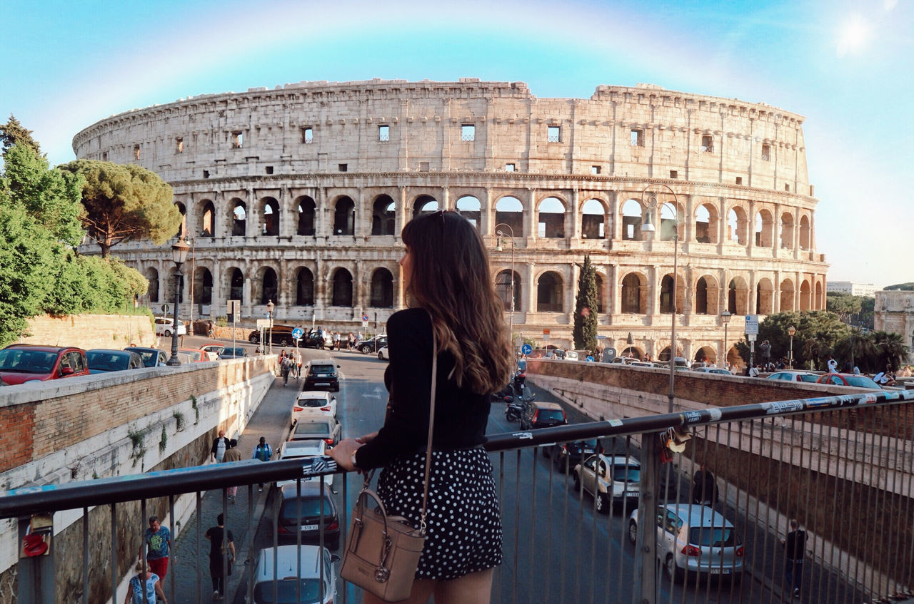 architecture, built structure, real people, history, the past, building exterior, travel destinations, lifestyles, amphitheater, women, travel, ancient, tourism, leisure activity, rear view, one person, adult, sky, young women, arch, hairstyle, hair, ancient civilization, archaeology