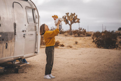 A woman with a baby is near an rv trailer, joshua tree, california