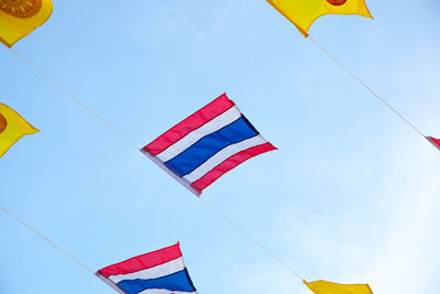 Low angle view of flag flags against blue sky