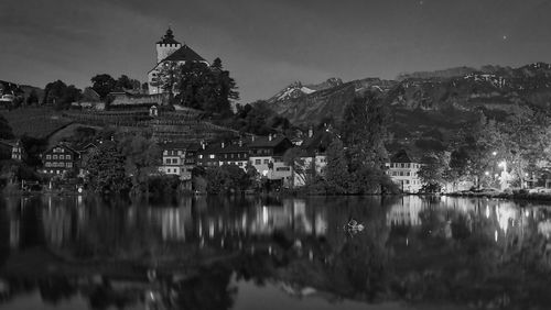 Reflection of buildings in lake at night